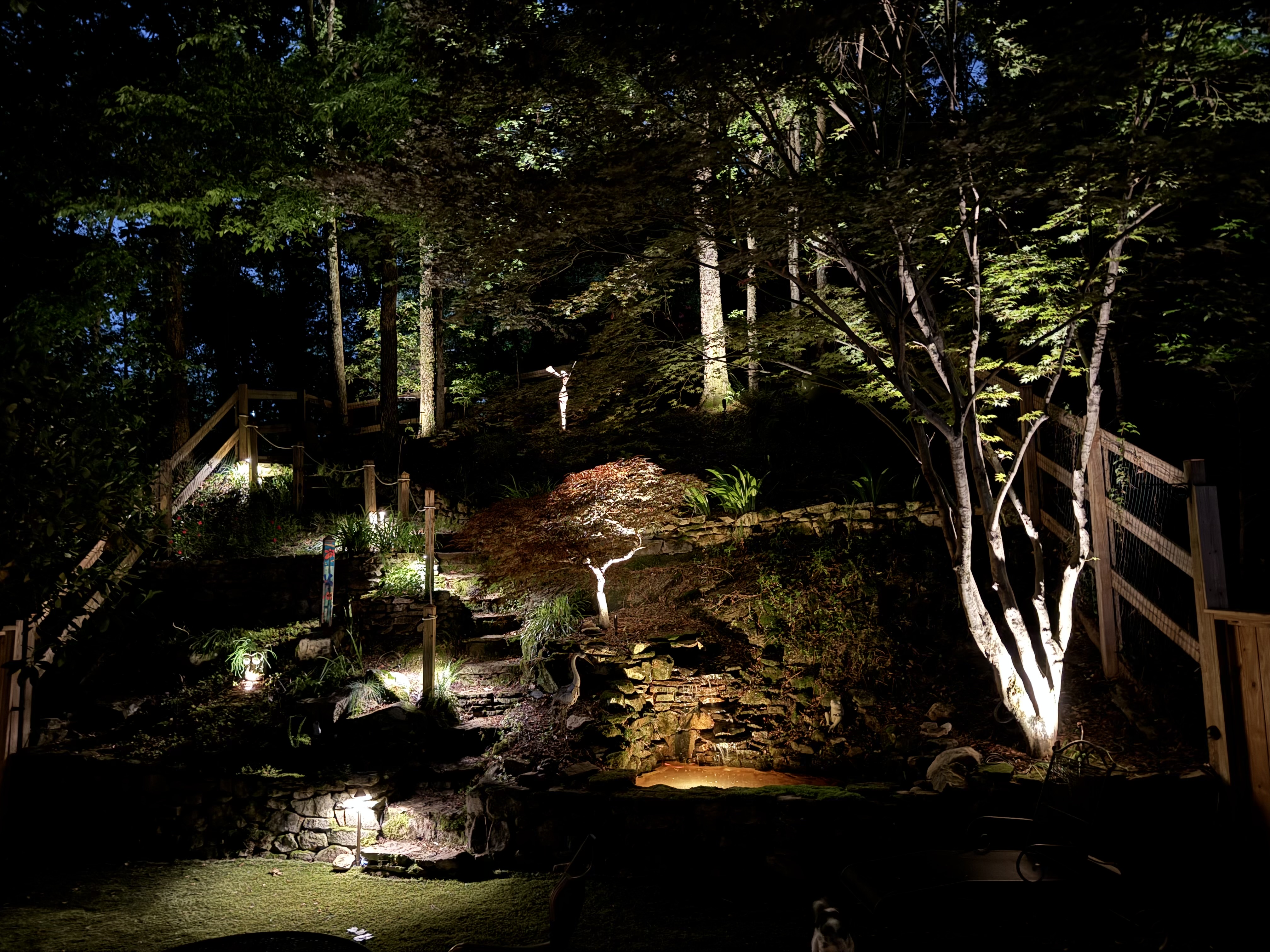 Landscape lighting along stone walkway and bridge